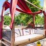 Teak Massivholz Daybed Jardin mit Baldachin, verstellbarem Kopfteil und Polster, in Handarbeit vom Schreiner gefertigt, fuer den Outdoor Bereich geeignet, Garten Moebel aus Massivholz Teak, Moebel Muenchen, Dekoration des Baldachins mit Stoff in rot und schoenen Kissen als Accessoires